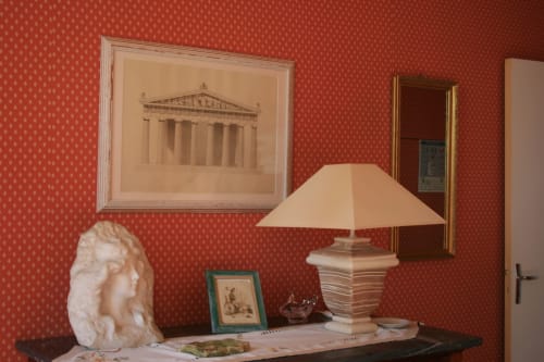Superior Room at La Chatellenie B&B with red patterned wallpaper, white bust sculpture, classical art, and cream desk lamp in