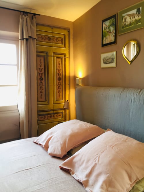 Cozy bedroom at Saint Martin B&B in Ollioules with mustard walls, wooden armoire, and cream pillows