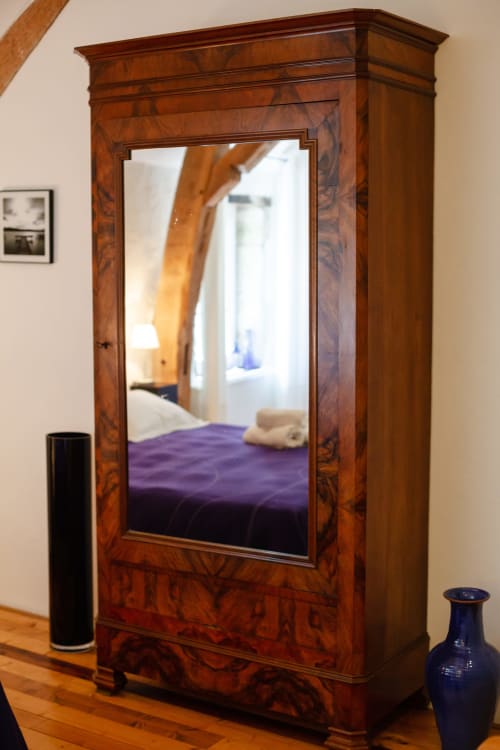 Antieke houten garderobekast met spiegel in de kamer Rolin van hotel Moulin Renaudiots, Autun, met reflectie van paars beddengoed