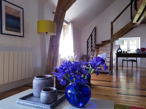 Arroux room at Moulin Renaudiots in Autun with purple iris flowers, wooden beams, yellow lamp and modern staircase