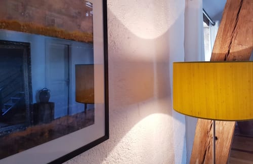 Modern sitting area in Arroux room at Moulin Renaudiots hotel, Autun, with yellow lamp and garden view