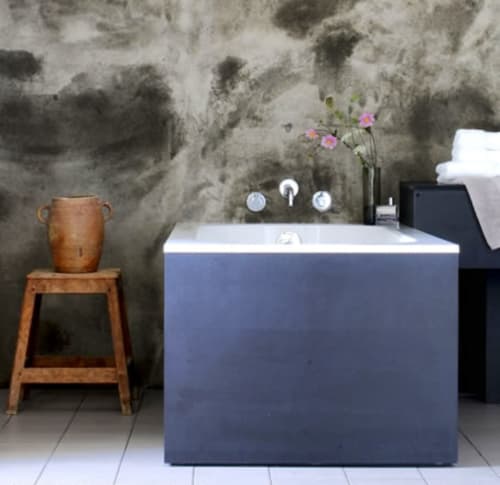 Moderne badkamer in Moulin Renaudiots in Autun met blauw bad, rustieke houten kruk en getextureerde grijze muur.