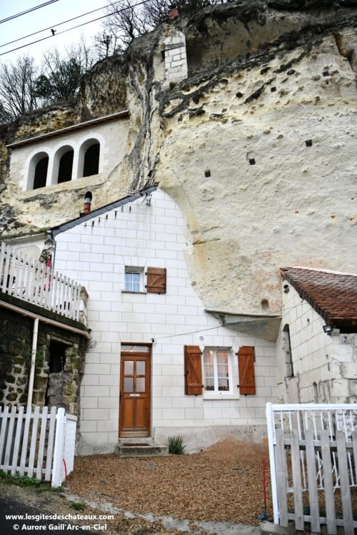 Charmante maison troglodytique aux Gîtes des Châteaux à Vallières-les-Grandes avec façade blanche, volets bois et habitation souterraine