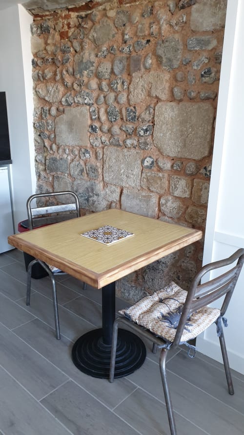 Coin repas douillet du gîte Vue D'ici à Saint Valery sur Somme avec mur en pierre rustique et table en bois