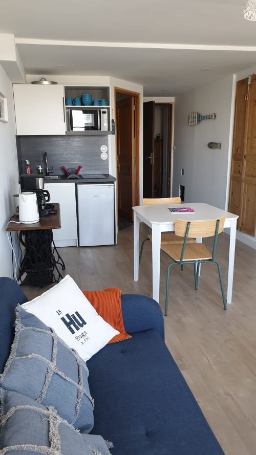 Cottage 312 à Vue D'ici B&B à Saint Valery sur Somme : kitchenette compacte, table à manger et coin détente bleu