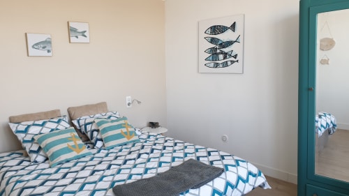 Chambre de cottage à Vue D'ici à Saint Valery sur Somme avec parure de lit géométrique bleue, œuvres marines et accès à la vue sur mer