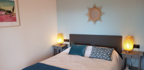 Cozy bedroom at Ty Pals B&B in Pals with sun mirror, warm lamps, and blue accents