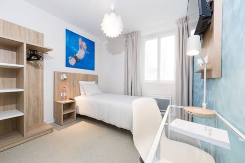 Chambre moderne à Un Air De Famille B&B à Vittel avec mobilier en bois, œuvres d'art bleues et vue sur le jardin