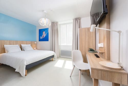 Chambre double moderne à Un Air De Famille B&B à Vittel avec mur d'accent bleu, mobilier en bois et accès au balcon