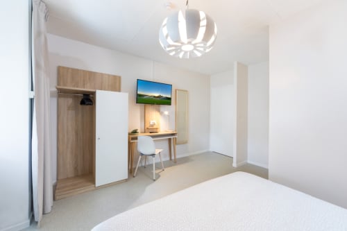 Chambre double moderne à Un Air De Famille à Vittel avec bureau, TV écran plat, armoire et vue sur le jardin