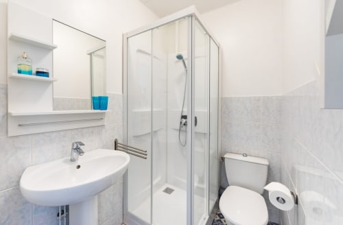 Salle de bain moderne avec lavabo sur colonne, douche à l'italienne et toilettes au gîte Un Air De Famille à Vittel, France