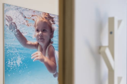 Jeune enfant nageant sous l'eau dans la piscine bleu clair du gîte Un Air De Famille à Vittel