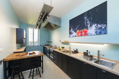 Cuisine moderne du gîte Un Air De Famille à Vittel avec murs bleu clair, meubles noirs et appareils en inox