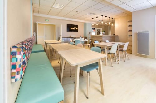 Salle à manger commune moderne au Un Air De Famille BnB à Vittel avec tables en bois, sièges turquoise et accents colorés