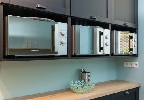 Coin cuisine moderne à l'Un Air De Famille B&B à Vittel avec trois fours à micro-ondes Brandt, murs menthe et comptoir en bois