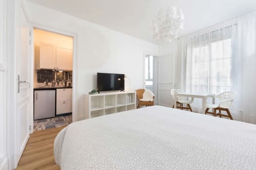 Chambre moderne lumineuse au B&B Un Air De Famille à Vittel avec lit, TV, kitchenette et vue sur la ville