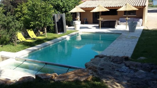 Piscine turquoise avec transats à La Maison D'ambrine, Chamaret, entourée de verdure et terrasse.