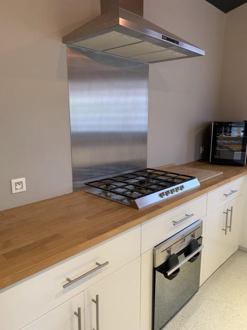 Cucina moderna nel gîte di Dylan a La Maison D'ambrine con cappa in acciaio inossidabile, piano cottura a gas, forno integrato e legno