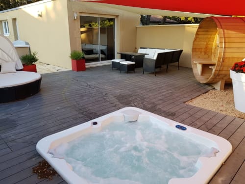 Terrasse luxueuse avec bain à remous, salon de détente, sauna en fût bois et terrasse moderne à La Maison D'ambrine, Chamaret