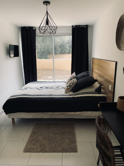Moderne slaapkamer van de suite Leny in La Maison D'ambrine, Chamaret met bed, geometrisch beddengoed, hanglamp en schuifpuien
