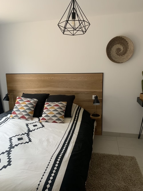Moderne slaapkamer in het huisje La Maison D'ambrine met houten hoofdeinde, geometrisch bedrukt beddengoed en geometrische wanddecoratie