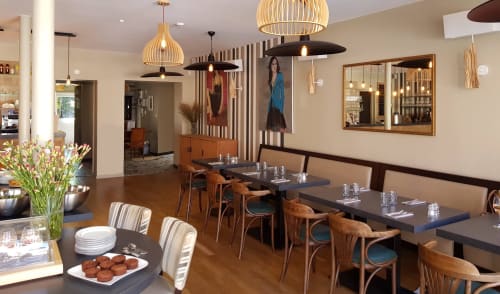 Restaurant de l'hôtel Les Cabines à Houlgate avec salle à manger moderne, chaises en bois et élégants luminaires suspendus