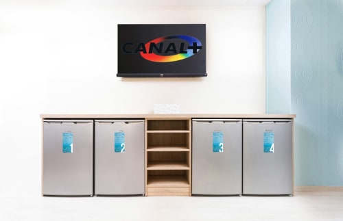 Enseigne CANAL+ TV au-dessus de mini-réfrigérateurs à Un Air De Famille BnB à Vittel, France