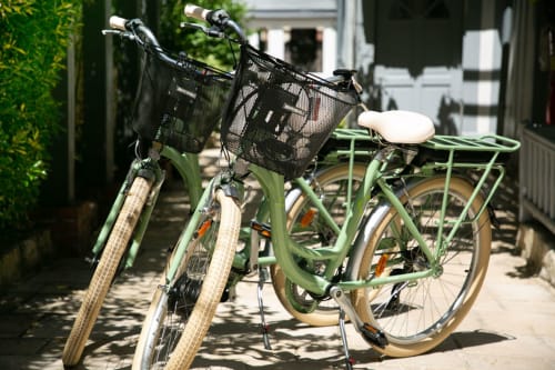 Vélos verts avec paniers garés devant l'hôtel Les Cabines à Houlgate, France