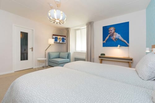 Suite petite et moderne à Un Air De Famille B&B à Vittel avec lit, coin salon et décoration contemporaine