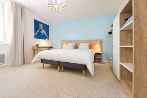 Suite moderne épurée à Un Air De Famille B&B à Vittel : lit bois clair, mur turquoise et style contemporain