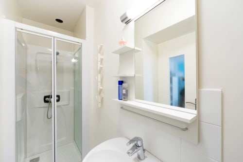 Salle de bain moderne de la Petite suite à Un Air De Famille B&B, Vittel, avec douche vitrée, miroir éclairé et équipements blancs