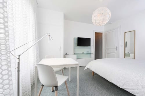 Chambre moderne à Un Air De Famille, Vittel avec mobilier blanc, télévision écran plat, espace de travail et lumière naturelle abondante