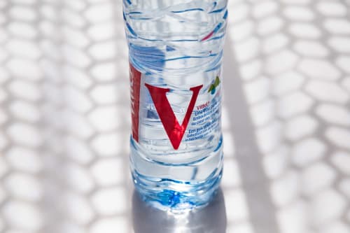 Bouteille d'eau Vittel avec logo V rouge à l'hébergement touristique Un Air De Famille