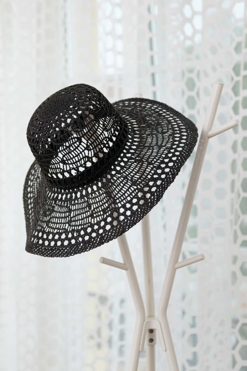 Chapeaux décoratifs en maille noire sur support blanc dans l'appartement Un Air De Famille, Vittel