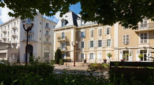 Hôtel-boutique Un Air De Famille à Vittel, France : bâtiments haussmanniens jaunes et blancs avec jardins paysagés
