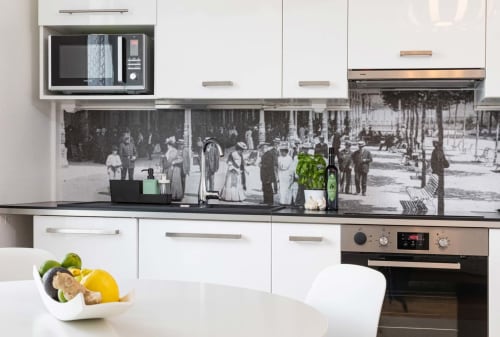 Cuisine moderne du studio Un Air De Famille à Vittel avec armoires blanches, plan de travail noir et décor de rue vintage