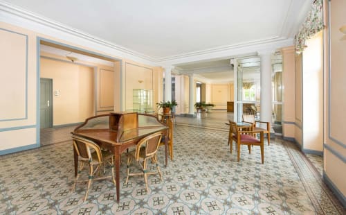 Élégant salon de détente au Un Air De Famille B&B à Vittel avec mobilier en bois et carrelage géométrique