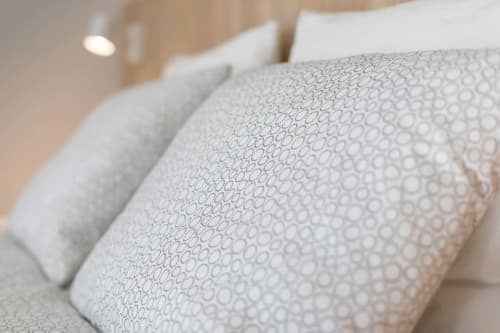 Gros plan sur des coussins moelleux aux motifs géométriques dans le studio Un Air De Famille, Vittel