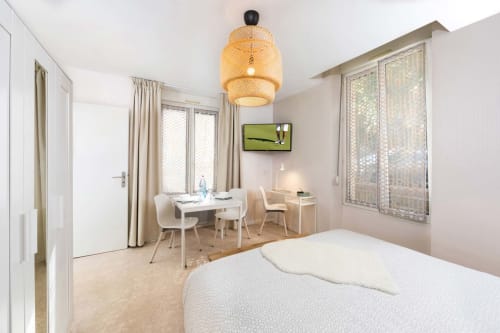 Studio moderne à Un Air De Famille à Vittel avec lit, table à manger et lampe suspendue tissée