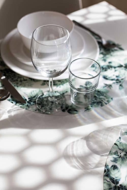 Mise en place élégante chez Un Air De Famille avec verre à vin, verre à eau et serviette à fleurs au Vittel B&B
