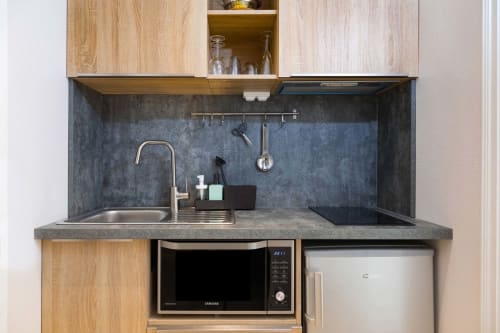 Kitchenette moderne à Un Air De Famille à Vittel avec plan de travail gris, évier inox et appareils compacts