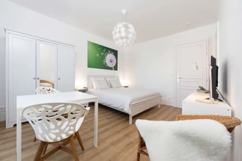 Studio 328 Un Air De Famille à Vittel : chambre moderne avec mobilier blanc, espace de travail, lit et décoration contemporaine