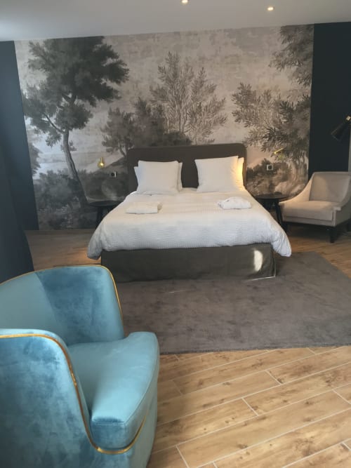 Modern superior double bedroom at Le château d'Hermonville with forest mural, white bedding, black bed frame, blue accent