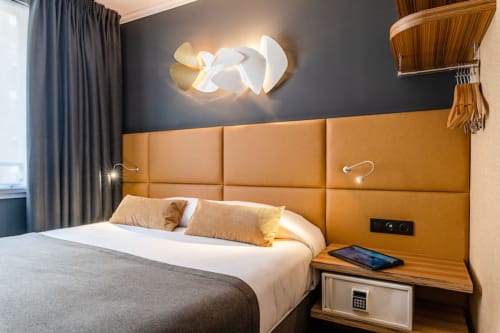 Classic Room at Hotel Residence Europe & Spa in Clichy, France, featuring a bed with mustard upholstered headboard and modern