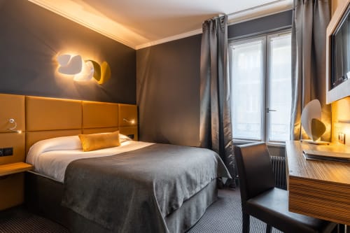 Modern Classic Room at Hotel Residence Europe & Spa in Clichy with orange headboard, neon wall art, and warm lighting