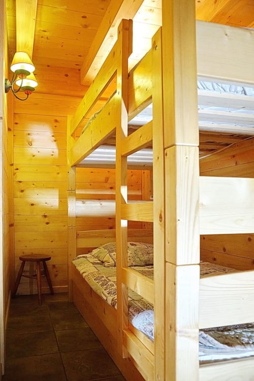 Chambre avec lits superposés en bois et matelas dans un chalet alpin douillet à La Toussuire, station de ski française