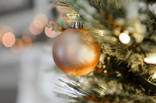 Goldene Weihnachtskugel an einer Tanne mit warmem Bokeh-Licht im Château d'Hassonville, Marche-en-Famenne, Belgien