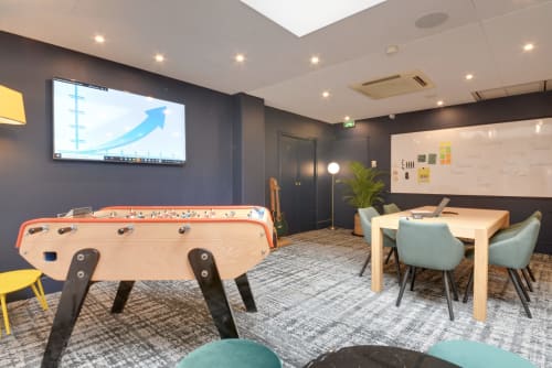 Modern game room at Hotel Residence Europe & Spa in Clichy with foosball table, work desk, whiteboard, and presentation