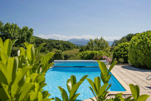 Belloréade B&B pool with mountain views in Belloc, France, surrounded by lush greenery and tropical plants