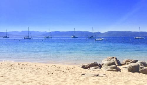 Playa de arena en Villas Marincelu con veleros anclados en aguas azul cristalino, Serra di Ferro, Córcega